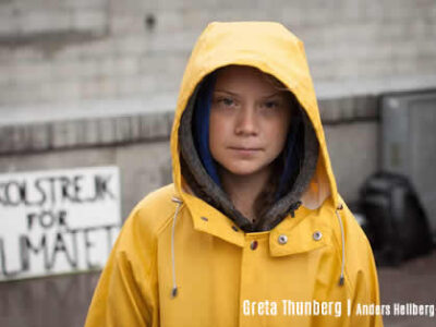 Climate 2020 | Photo portrait of Greta Thunberg in yellow sou'wester, hood up looking directly at you - credit Anders Helberg | Effeckt