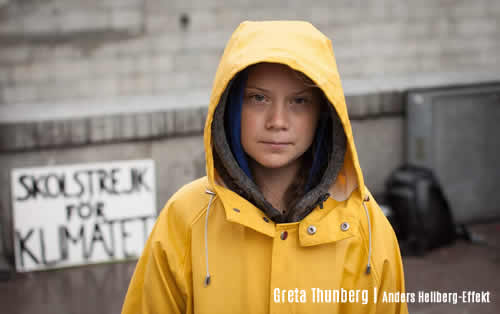 Climate 2020 | Photo portrait of Greta Thunberg in yellow sou'wester, hood up looking directly at you - credit Anders Helberg | Effeckt