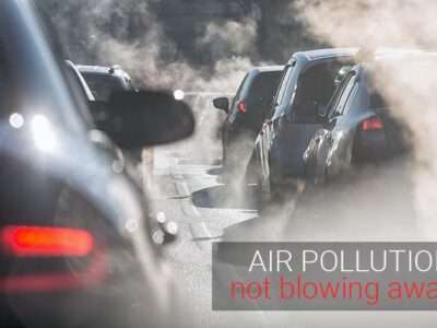 Small particle air pollution - cars on street, back lit air pollution
