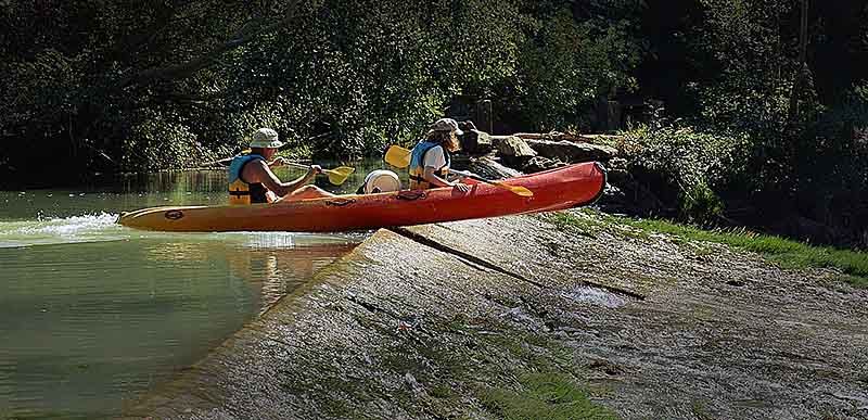 sustainable-business-challenges-2023-Image of two people in kayak hitting a dam with no water beyond it