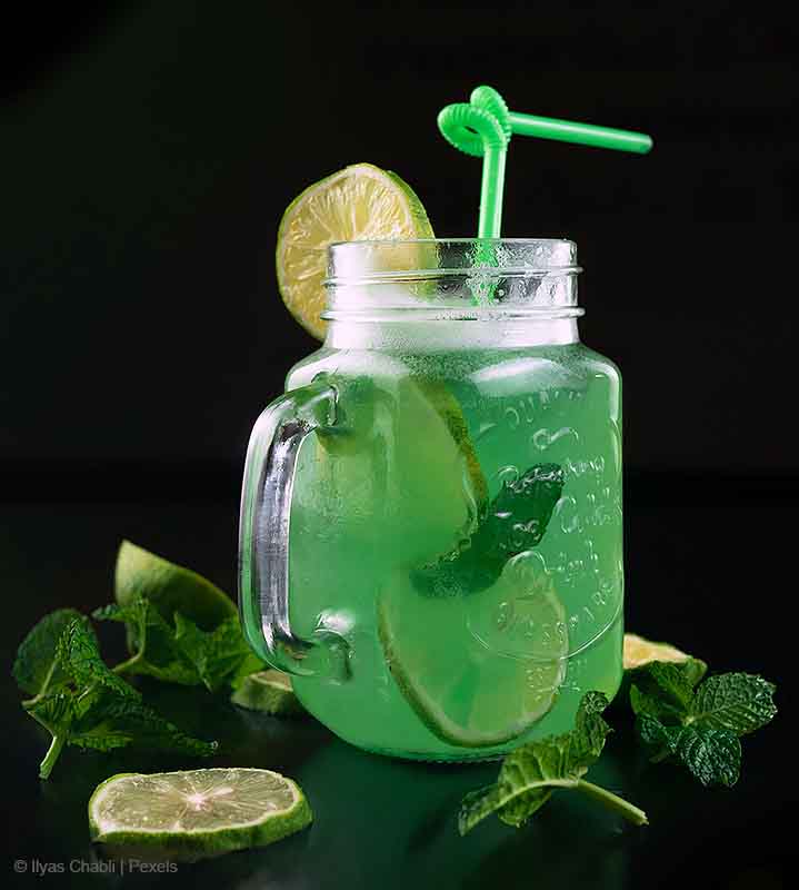 Photo of glass mug filled with a green cocktail and crucially a green straw - a foundation of our sustainable approach