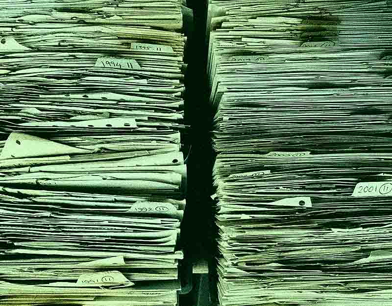 The Greenwash files - digest of notable developments and regulatory action on greenwashing | Stylised grainy, green tinted photo of 2 stacks of paper files