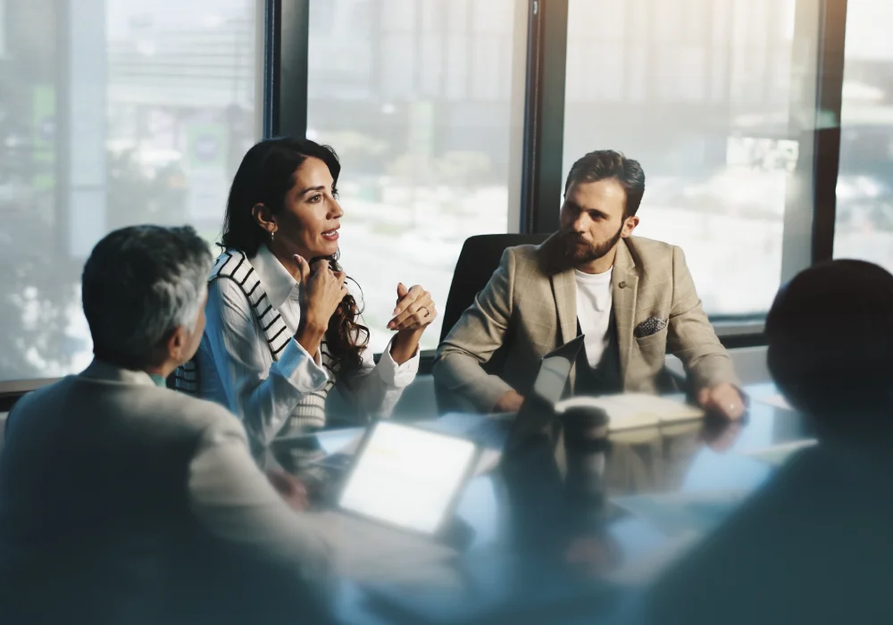 A group of people in a board room sat around a table.