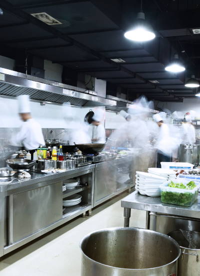 Cooks working speedily in a commercial kitchen.